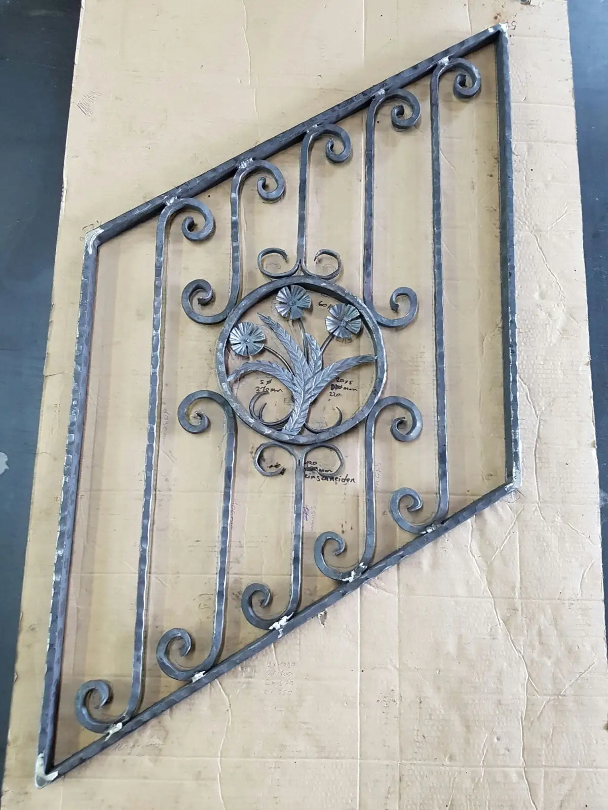 Detail eines geschmiedeten Ziergitters mit Blütenrosette und tordierten Stäben
