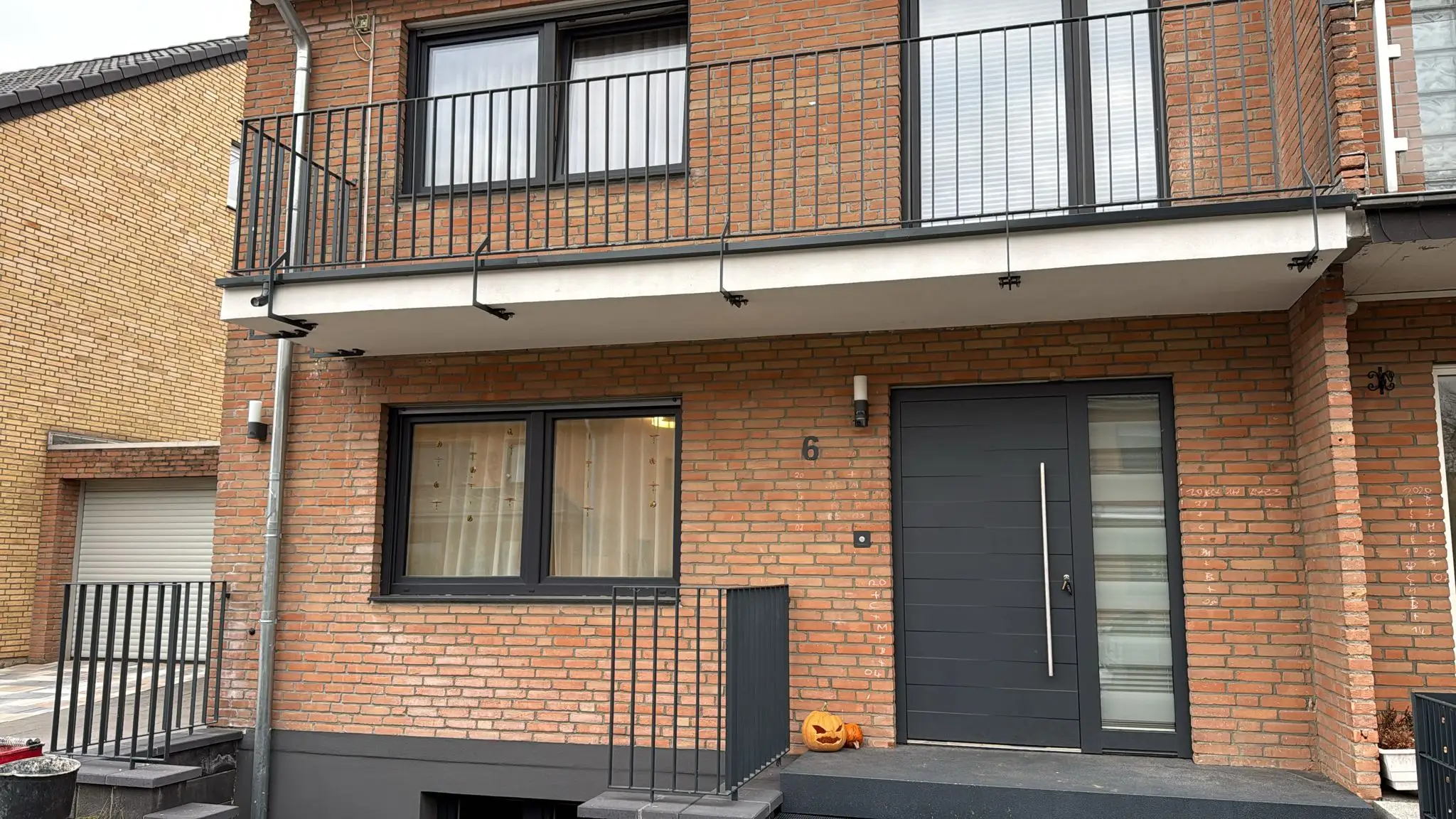 Balkongeländer und französischer Balkon aus schwarzem Stahl an einem Klinkerhaus