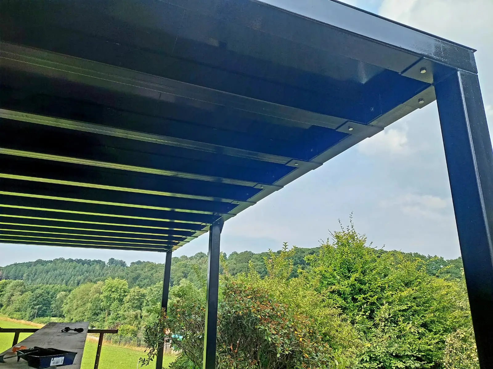 Untersicht einer Stahl-Balkonanlage mit Trägerrost und Stützen, Blick ins Tal